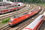 ÖBB 1116 133-0 und 1016 010-8 fahren mit einem langen, leeren Containerzug aus dem Güterbahnhof in Ulm am 09.06.2012.