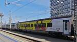 Farbenfroher railjet Personenwagen, aufgenommen bei der Ausfahrt aus dem Hauptbahnhof von Wien.