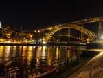 Brücke Ponte Luiz I bei Nacht; vorn am Ufer ist ein Portweinschiff am Anleger in Porto am 14.05.2018.