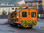 Die RhB Tm 2/2 22, ex RhB Tm 2/2 58, steht am 02.11.2019 mit drei angehangenen und mit Rundholz beladenen Flachwagen vom Typ “Sp-w“ der Serie 8271 – 8300 beim Bahnhof Tirano.