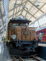 
Das Rhätisches Krokodil 411 bzw. die RhB Ge 6/6 I 411, ausgestellt im Verkehrszentrum des Deutschen Museums in München (Theresienhöhe), hier am 16.06.2018.

Die Ge 6/6 I ist eine Elektrolokomotivbaureihe der Rhätischen Bahn (RhB). Wegen ihrer Form und Konstruktion – sie ähneln den SBB-Krokodilen der Gotthardbahn – werden die C'C'-Lokomotiven von Eisenbahnfreunden auch Rhätisches Krokodil genannt, RhB-intern ist C-C die geläufige Bezeichnung.

Die Ge 6/6 I Rh.B. 411 wurde 1925 von A.G. Brown, Boveri & Cie. (Fabrik-Nr. 2241), der Schweizerische Lokomotiv- und Maschinenfabrik Winterthur (Fabrik-Nr. 3344), sowie der Maschinenfabrik Oerlikon gebaut.

Die fortschreitende Elektrifizierung des RhB Stammnetzes mit Einphasenwechselstrom (11 kV, 16 2/3 Hz) zwang die RhB Anfang der 20er Jahre des vergangenen Jahrhunderts zur Beschaffung leistungsfähiger Elektrolokomotiven.
1921 konnten die ersten sechs sechsachsigen Lokomotiven des Typs Ge 6/6 in Betrieb genommen werden. Diese Fahrzeuge, die seinerzeit als die leistungsstärksten Schmalspurlokomotiven der Welt galten, verdrängten schnell die Dampflokomotiven auf der Albulalinie. 1924 konnten vier, 1925 weitere zwei und schließlich 1929 nochmals drei Lokomotiven dieses Types in Dienst gestellt werden.
Mit Auslieferung der Ge 4/4 I und Ge 6/6 II wurden die als Rhätisches Krokodil bekannten Ge 6/6 I in den Güterzugdienst abgeschoben. Dennoch prägten diese Fahrzeuge über Jahrzehnte das Bild der RhB und gelten daher bei vielen Fans noch heute als die RhB-Lokomotive schlechthin.
Erst mit Verfügbarkeit der zweiten Serie der Ge 4/4 II wurde ein Großteil der Krokodile entbehrlich. Nur noch drei Exemplare verblieben auf dem Netz der RhB und stehen noch heute hauptsächlich für Sonderfahrten zur Verfügung.

Das eine oder andere RhB Krokodil blieb der Nachwelt als Denkmallokomotive erhalten. Lok 402 ist seit 1985 im Verkehrshaus der Schweiz in Luzern ausgestellt. Die Nummer 407 stand viele Jahre lang vor einem Zürcher Bankhaus. Sie wurde jedoch wieder nach Graubünden verfrachtet und steht heute auf einem Denkmal in der Nähe des Bahnhofs Bergün. Lok 406 wurde 1984 auf dem ehemaligen ABB Areal in Zürich Oerlikon aufgestellt und später im Werk Pratteln ausgestellt. Dieses äußerlich sehr gut erhaltene Exemplar ist leider nicht der Öffentlichkeit zugänglich. Nummer 413 wurde 1996 verschrottet. Nach einem Rangierunfall wurde die Ge 6/6 411 zusammen mit dem Salonwagen As 1154 im Juni 2001 an das Deutsche Museum in München als Leihgabe abgegeben.

TECHNISCHE DATEN der RhB Ge 6/6 I (Rhätisches Krokodil):
Betriebsnummern: 401 - 415
Hersteller - Kasten und Drehgestelle: SLM
Hersteller - Elektrik: BBC, MFO
Inbetriebsetzung: 1921 - 29
Anzahl Fahrzeuge: 15 (betriebsfähig 2, erhalten 6)
Spurweite: 1.000 mm
Achsanordnung: C'C'
Länge über Puffer: 13.300 mm
Breite: 2.650 mm
Drehzapfenabstand: 5.670 mm
Achsabstand im Drehgestell: 3.275 mm
Triebraddurchmesser (neu): 1.070 mm
Dienstgewicht: 65,9 t
Höchstgeschwindigkeit: 55 km/h
Anzahl Fahrmotoren: 2 vom Typ ELM 86/12
Getriebeübersetzung: 1 : 4,134
Max. Leistung am Rad: 940 kW
Stundenleistung: 794 kW (1076 PS)
Max. Zugkraft am Rad: 195 kN
Dauerzugkraft am Rad: 115 kN
Anhängelast: bei 45 ‰ 160 t / bei 35 ‰ 220 t
Fahrleitungsspannung: 11 kV, AC 16,7 Hz