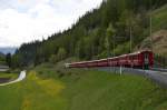 Der Schnellzug St. Moritz - Chur verlässt am 11.05.2014 nach kurzem Halt den Bahnhof Bergün und fährt in Richtung Filisur.