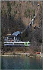 Während das Trasse der Harderbahn steil bergauf führt, fährt ein BLS Regionalzug der Aare entlang und wird in Kürze in Interlaken Ost ankommen.