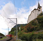 Stalden, MGB: Blick hinauf zur Kirche Stalden, mit einem Zug mit der Lok 3. Die Lok zieht weder den Glacier-Express noch einen Güterzug, sondern einen  normalen  Pendelzug, am Ende mit dem ehemaligen BVZ-Steuerwagen BDt 2241. 30.August 2025 