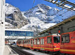 Die  neue  Jungfraubahn: Die beiden Doppeltriebwagen 216-218 pendeln von Eigergletscher zur Kleinen Scheidegg, während im Hintergrund der dreiteilige Triebwagen 223 aus dem neuen Bahnhof