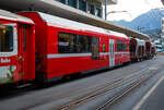 Der vierachsige RhB Bt 528 02 Universalsteuerwagen mit zweite Klasseabteil am 07 September 2021im Zugverband in Chur am Bahnhofsvorplatz, dahinter noch zwei vierachsiger Drehgestell-Schotterwagen