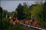 S-Bahn-Entgleisung Berlin Tegel: Die Arbeiten an der Stromschiene gehen voran. Im Hintergrund stehen die weggeschleppten Wagen und rechts noch der einzelne Kopfwagen auf dem toten Gleis (Berlin Tegel 23.08.2012)