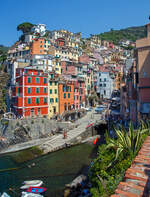 Riomaggiore (Cinque Terre) am 21.07.2022, hier der Blick auf die Bucht und das Zentrum mit den sich gegeneinander auft�rmenden bunten Hausfassaden in allen m�glichen Farbt�nen.