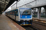 Der RegioNova „Trio“ 814 201-0 / 014 0xx / 814 202-9 steht am 23.11.2022 als Regionalzug im Hauptbahnhof Prag (Praha hlavní nádraží) zur Abfahrt bereit.